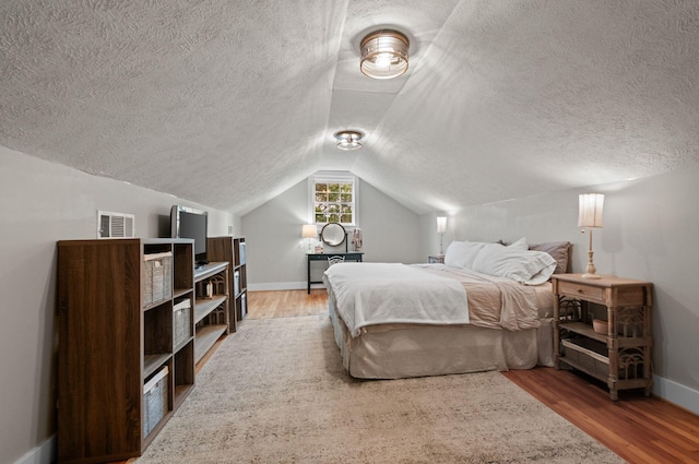 909 W 1st St, Dickson, TN 37055 - bedroom with wood finished floors, a textured ceiling, and lofted ceiling