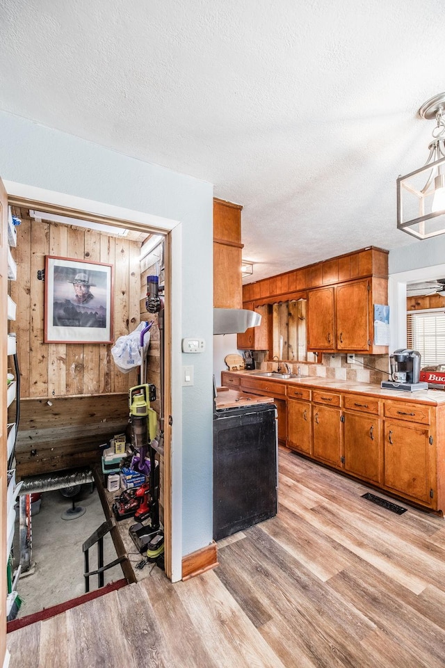 305 Bryant St, Watertown, TN 37184 - kitchen featuring wood walls, range, brown cabinetry, exhaust hood, and light countertops