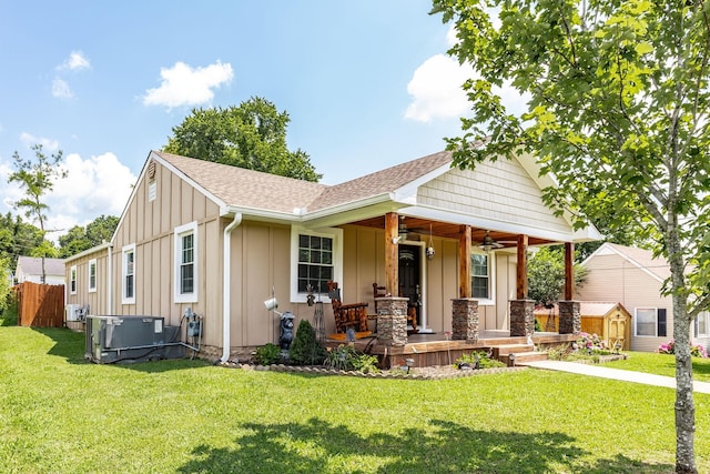 305 Bryant St, Watertown, TN 37184 - view of front facade with covered porch, board and batten siding, a ceiling fan, a storage shed, and a shingled roof