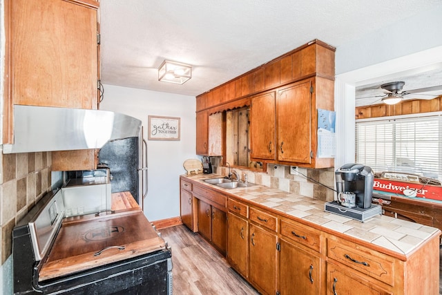 305 Bryant St, Watertown, TN 37184 - kitchen with tile countertops, light wood finished floors, a ceiling fan, tasteful backsplash, and brown cabinetry