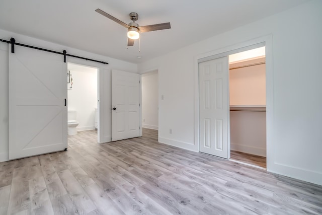 4819 Whites Creek Pike, Whites Creek, TN 37189 - unfurnished bedroom with a barn door, light wood-style floors, a closet, connected bathroom, and ceiling fan