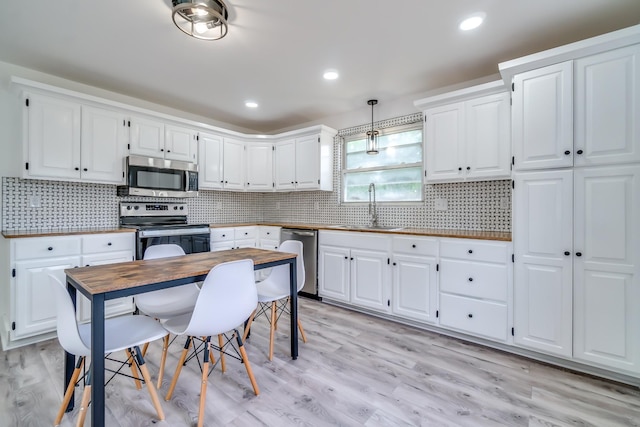 4819 Whites Creek Pike, Whites Creek, TN 37189 - kitchen with appliances with stainless steel finishes, white cabinetry, decorative backsplash, light wood-style flooring, and recessed lighting
