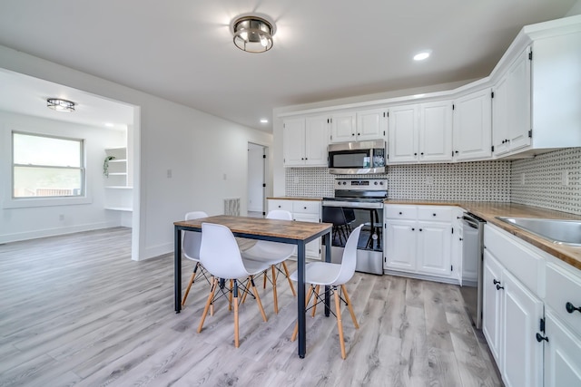 4819 Whites Creek Pike, Whites Creek, TN 37189 - kitchen with appliances with stainless steel finishes, tasteful backsplash, light wood finished floors, white cabinets, and recessed lighting