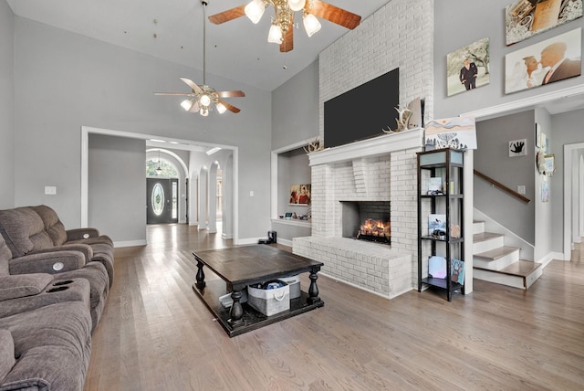 3723 Reed Rd, Indian Mound, TN 37079 - living area with ceiling fan, a brick fireplace, high vaulted ceiling, wood finished floors, and stairway