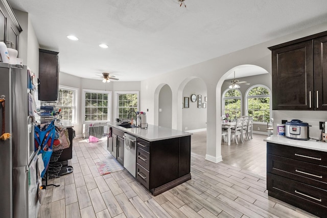 3723 Reed Rd, Indian Mound, TN 37079 - kitchen featuring a ceiling fan, arched walkways, stainless steel appliances, light countertops, and light wood-style floors