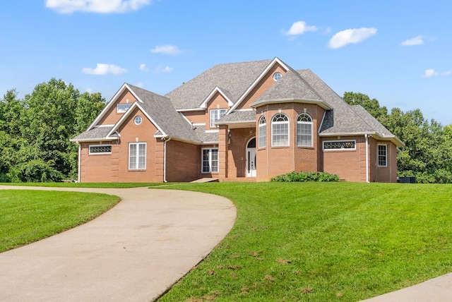 3723 Reed Rd, Indian Mound, TN 37079 - view of front of property with brick siding, a front yard, curved driveway, and a shingled roof