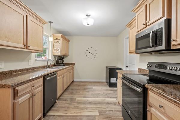 414 Grace St, Springfield, TN 37172 - kitchen with appliances with stainless steel finishes, light brown cabinetry, light wood-style flooring, and decorative light fixtures