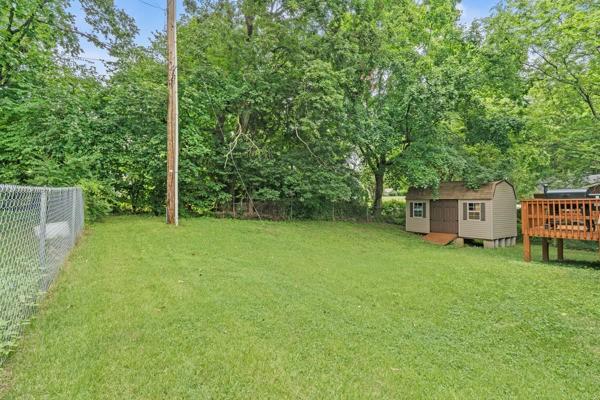 414 Grace St, Springfield, TN 37172 - fenced backyard featuring a wooden deck and a storage unit