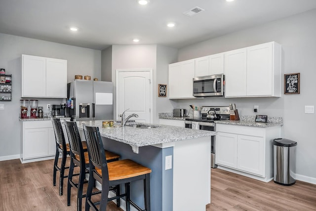 124 Nunally Dr, Baxter, TN 38544 - kitchen featuring stainless steel appliances, a kitchen island with sink, light wood-style flooring, a breakfast bar, and recessed lighting