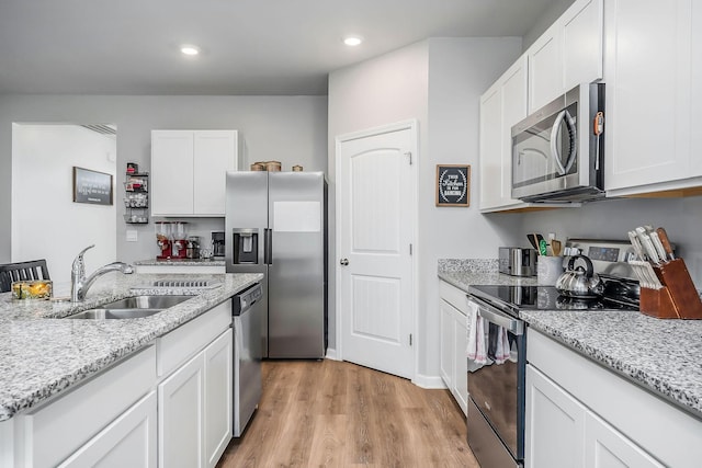 124 Nunally Dr, Baxter, TN 38544 - kitchen with appliances with stainless steel finishes, light wood-type flooring, white cabinets, recessed lighting, and light stone countertops