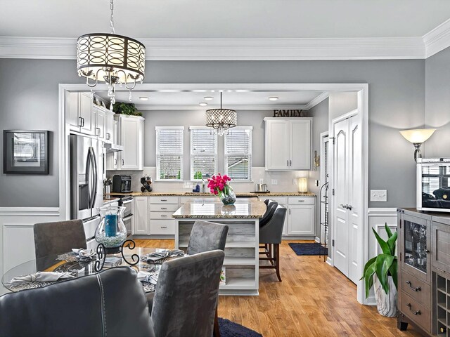 141 Tipton Pass, Spring Hill, TN 37174 - kitchen with stainless steel fridge with ice dispenser, light stone counters, white cabinets, open shelves, and crown molding