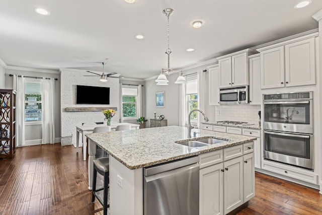 2188 Capistrano Way, Nolensville, TN 37135 - kitchen with appliances with stainless steel finishes, ornamental molding, a ceiling fan, pendant lighting, and a kitchen island with sink