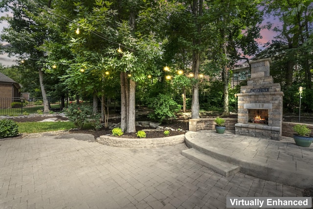 2188 Capistrano Way, Nolensville, TN 37135 - patio terrace at dusk featuring an outdoor stone fireplace and a patio