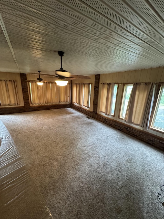 3911 Old Bottom Rd, Lafayette, TN 37083 - unfurnished living room with carpet floors, wood walls, and a ceiling fan