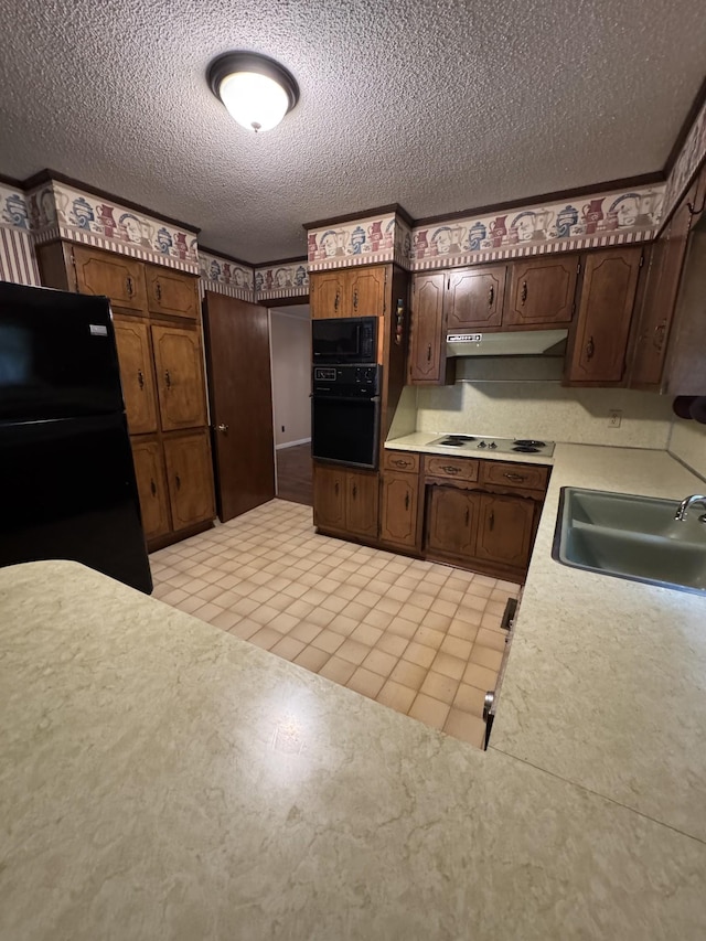 3911 Old Bottom Rd, Lafayette, TN 37083 - kitchen featuring black appliances, light countertops, under cabinet range hood, a textured ceiling, and dark brown cabinetry