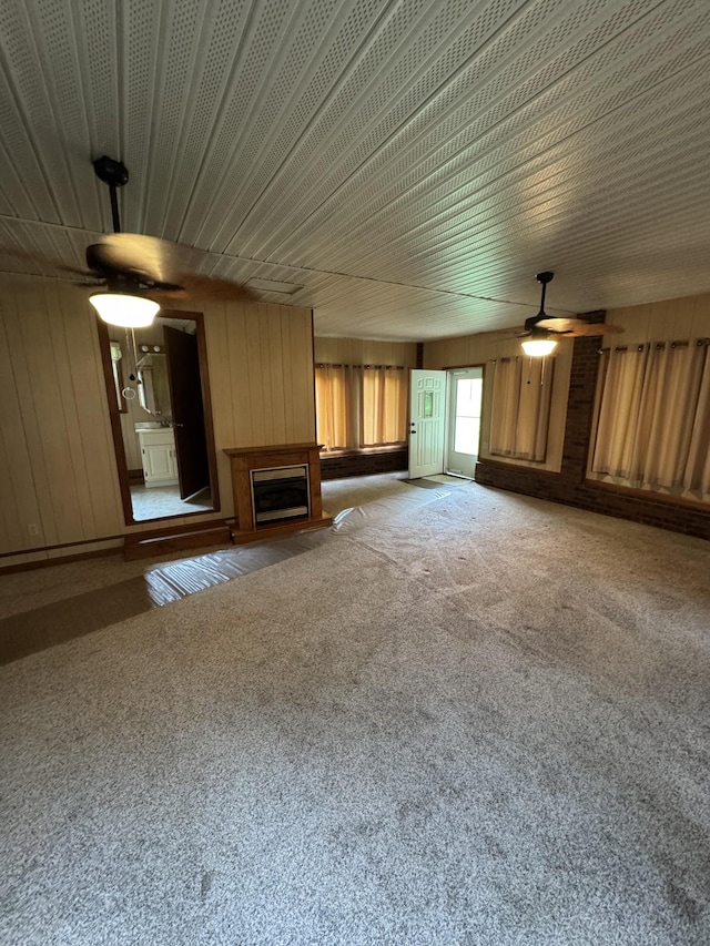3911 Old Bottom Rd, Lafayette, TN 37083 - unfurnished living room featuring a ceiling fan, carpet flooring, wooden walls, and a fireplace