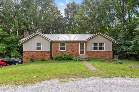 101 Cedar Hill Dr, Waverly, TN 37185 - ranch-style house featuring brick siding, a chimney, and a front yard