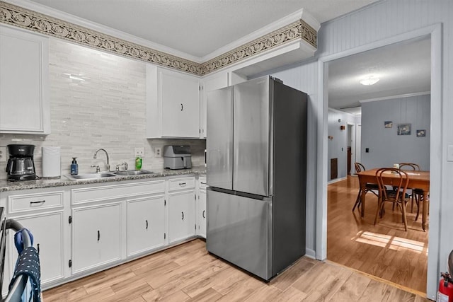 101 Cedar Hill Dr, Waverly, TN 37185 - kitchen with freestanding refrigerator, crown molding, decorative backsplash, white cabinets, and light wood-style floors