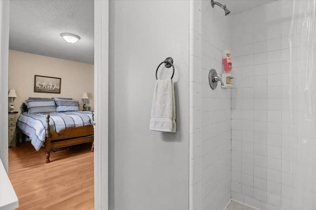 101 Cedar Hill Dr, Waverly, TN 37185 - bathroom with tiled shower, wood finished floors, connected bathroom, and a textured ceiling