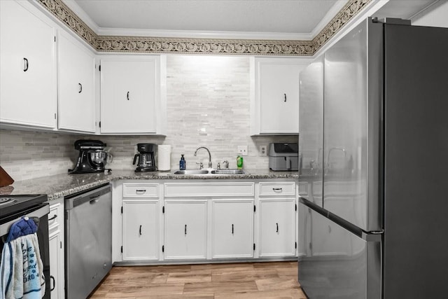 101 Cedar Hill Dr, Waverly, TN 37185 - kitchen with appliances with stainless steel finishes, white cabinets, ornamental molding, light wood finished floors, and decorative backsplash