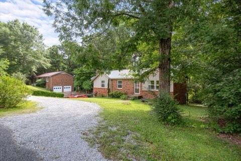 101 Cedar Hill Dr, Waverly, TN 37185 - view of grassy yard featuring an outdoor structure and gravel driveway