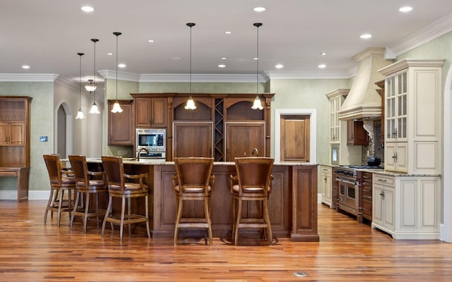 11 Saint Nicholas Way, Signal Mountain, TN 37377 - kitchen with appliances with stainless steel finishes, premium range hood, light wood-style floors, a breakfast bar area, and recessed lighting