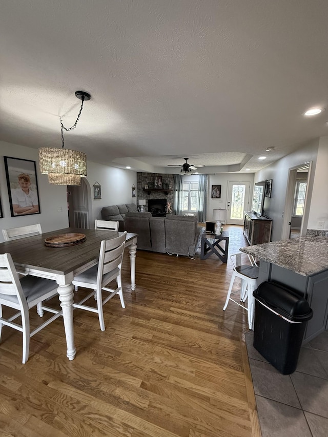 273 Old Coleytown Ln, Lafayette, TN 37083 - dining space featuring a ceiling fan, wood finished floors, a stone fireplace, a textured ceiling, and recessed lighting