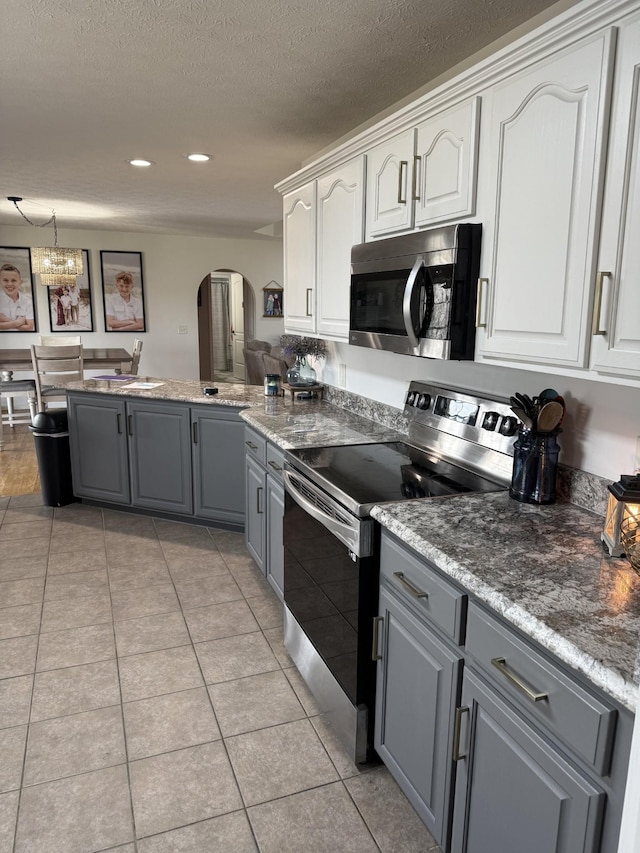 273 Old Coleytown Ln, Lafayette, TN 37083 - kitchen featuring stainless steel appliances, arched walkways, gray cabinets, white cabinetry, and a chandelier