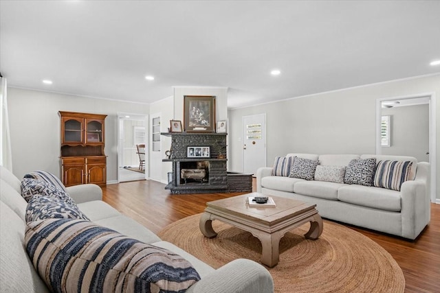 215 Sunset Dr, New Johnsonville, TN 37134 - living area with wood finished floors, crown molding, healthy amount of natural light, a stone fireplace, and recessed lighting