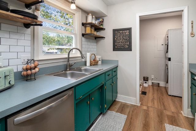 614 Joshua Dr, Clarksville, TN 37042 - kitchen with stainless steel dishwasher, estacked washer and dryer, open shelves, and wood finished floors