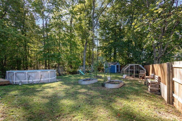614 Joshua Dr, Clarksville, TN 37042 - fenced backyard featuring a playground, an outdoor pool, and a storage unit