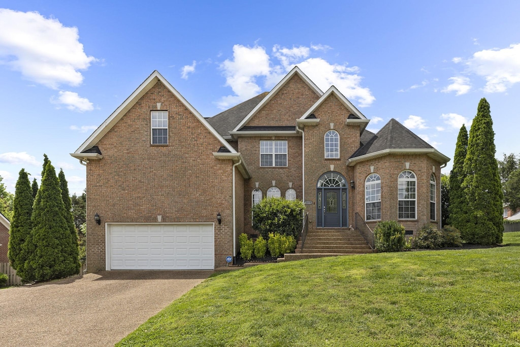 5579 Hill Rd, Brentwood, TN 37027 - view of front of home featuring asphalt driveway, brick siding, an attached garage, and a front lawn