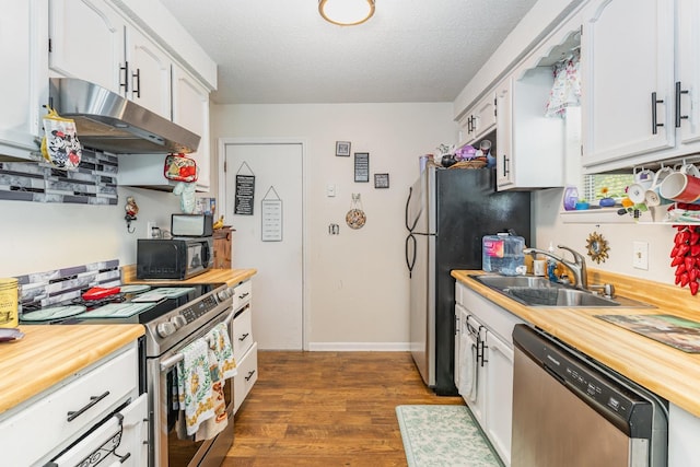1205 Bloom Landing Rd, Charlotte, TN 37036 - kitchen featuring appliances with stainless steel finishes, under cabinet range hood, dark wood-style floors, white cabinets, and butcher block counters