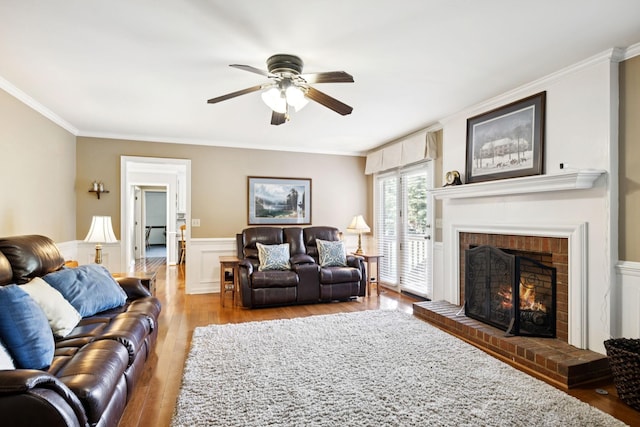 9214 Hunterboro Dr, Brentwood, TN 37027 - living room with a ceiling fan, ornamental molding, wood finished floors, a brick fireplace, and wainscoting