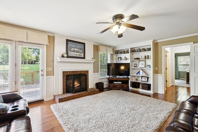 9214 Hunterboro Dr, Brentwood, TN 37027 - living room with wood finished floors, ornamental molding, ceiling fan, a fireplace, and wainscoting