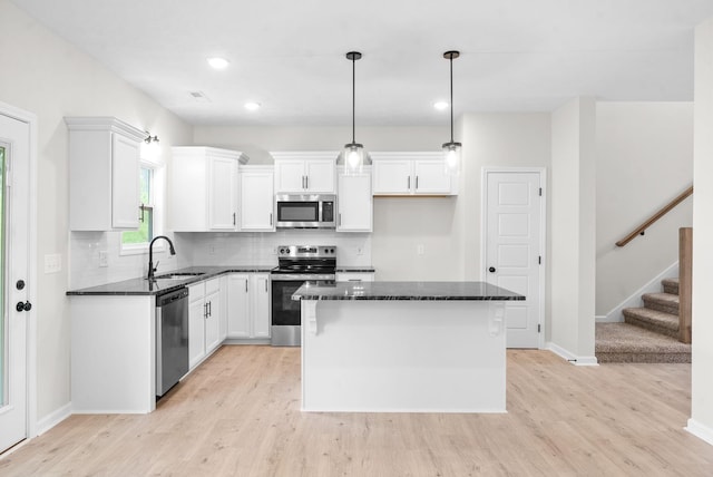 1220 Boulder Pass Rd, Clarksville, TN 37040 - kitchen with appliances with stainless steel finishes, light wood finished floors, tasteful backsplash, white cabinets, and recessed lighting