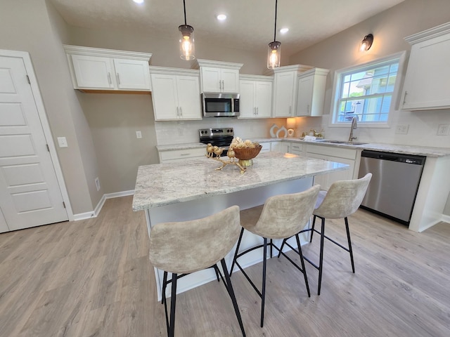 1204 Boulder Pass Rd, Clarksville, TN 37040 - kitchen featuring stainless steel appliances, white cabinetry, light wood-type flooring, a kitchen island, and recessed lighting