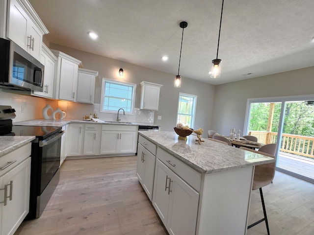 1204 Boulder Pass Rd, Clarksville, TN 37040 - kitchen with electric range, stainless steel microwave, a center island, backsplash, and a breakfast bar
