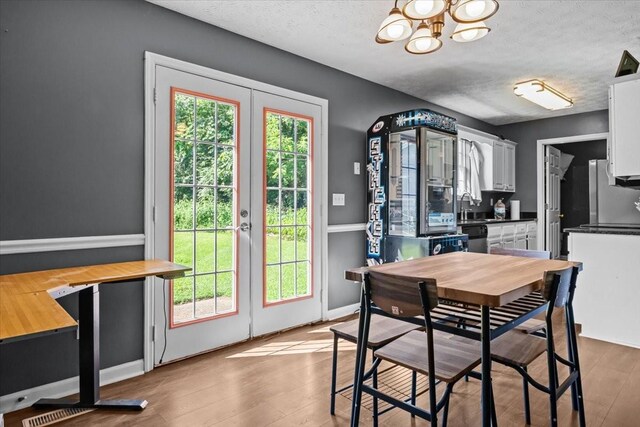 7173 New Hope Rd, Fairview, TN 37062 - dining space featuring french doors, a chandelier, light wood-type flooring, and a textured ceiling