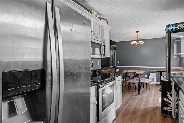 7173 New Hope Rd, Fairview, TN 37062 - kitchen with stainless steel appliances, dark wood-style flooring, white cabinets, a chandelier, and dark countertops