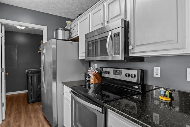 7173 New Hope Rd, Fairview, TN 37062 - kitchen with appliances with stainless steel finishes, electric panel, dark wood-style floors, white cabinets, and dark stone counters