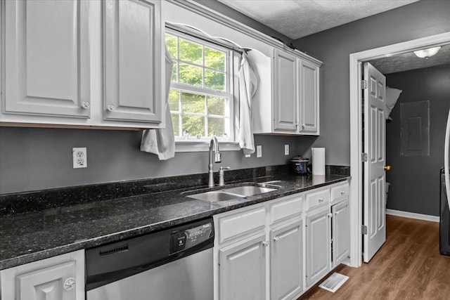 7173 New Hope Rd, Fairview, TN 37062 - kitchen featuring stainless steel dishwasher, electric panel, wood finished floors, white cabinets, and a textured ceiling