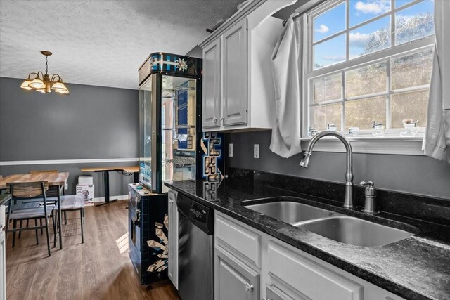 7173 New Hope Rd, Fairview, TN 37062 - kitchen with stainless steel dishwasher, dark wood-style floors, a textured ceiling, a chandelier, and hanging light fixtures