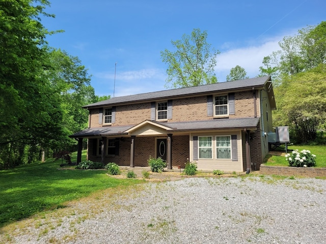 3388 Budds Creek Rd, Palmyra, TN 37142 - view of front of property featuring a front yard, covered porch, brick siding, and driveway