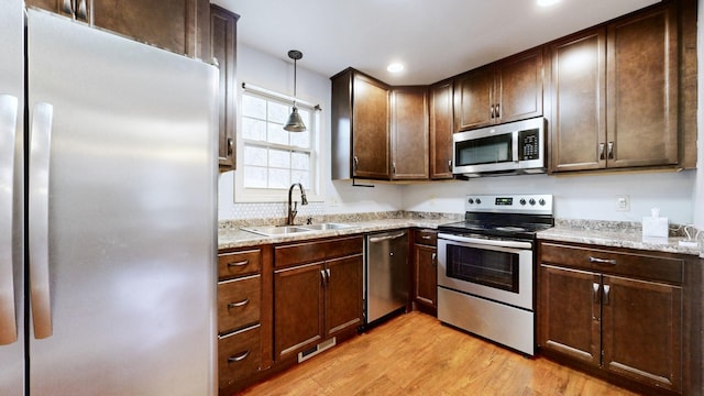 3388 Budds Creek Rd, Palmyra, TN 37142 - kitchen featuring stainless steel appliances, light wood-style flooring, decorative light fixtures, dark brown cabinetry, and recessed lighting