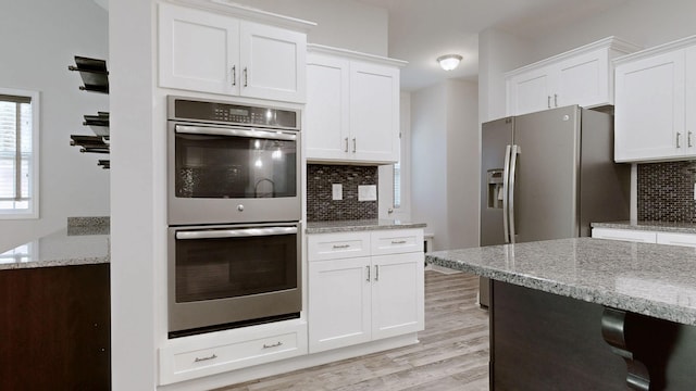 1012 Michaela Cir, Clarksville, TN 37043 - kitchen featuring appliances with stainless steel finishes, tasteful backsplash, white cabinetry, and light wood-style floors