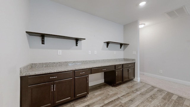1012 Michaela Cir, Clarksville, TN 37043 - kitchen with open shelves, light wood-style floors, dark brown cabinets, light countertops, and built in study area