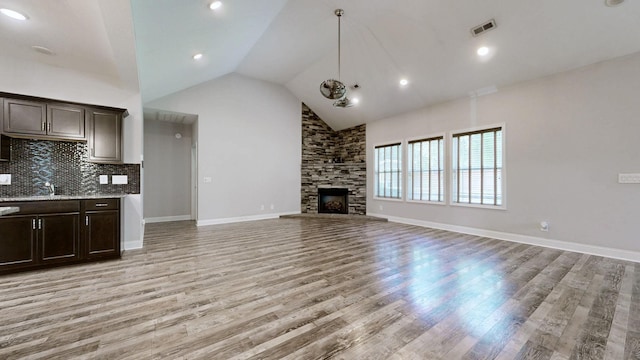 1012 Michaela Cir, Clarksville, TN 37043 - unfurnished living room with light wood finished floors, a fireplace, and high vaulted ceiling