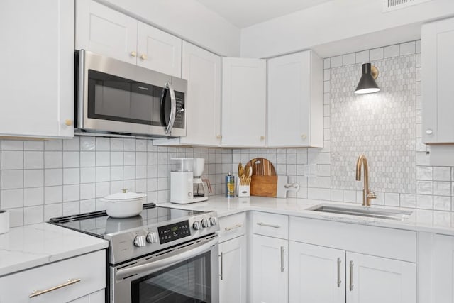 5813 Brentwood Trce, Brentwood, TN 37027 - kitchen featuring appliances with stainless steel finishes, white cabinets, tasteful backsplash, and light stone counters