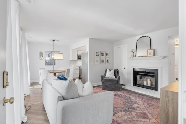 5813 Brentwood Trce, Brentwood, TN 37027 - living area with a glass covered fireplace, light wood-style flooring, and a chandelier